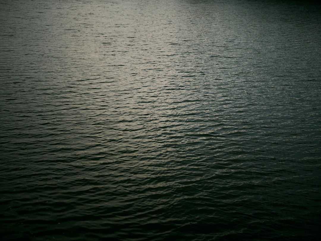 a large body of water with a boat in the distance