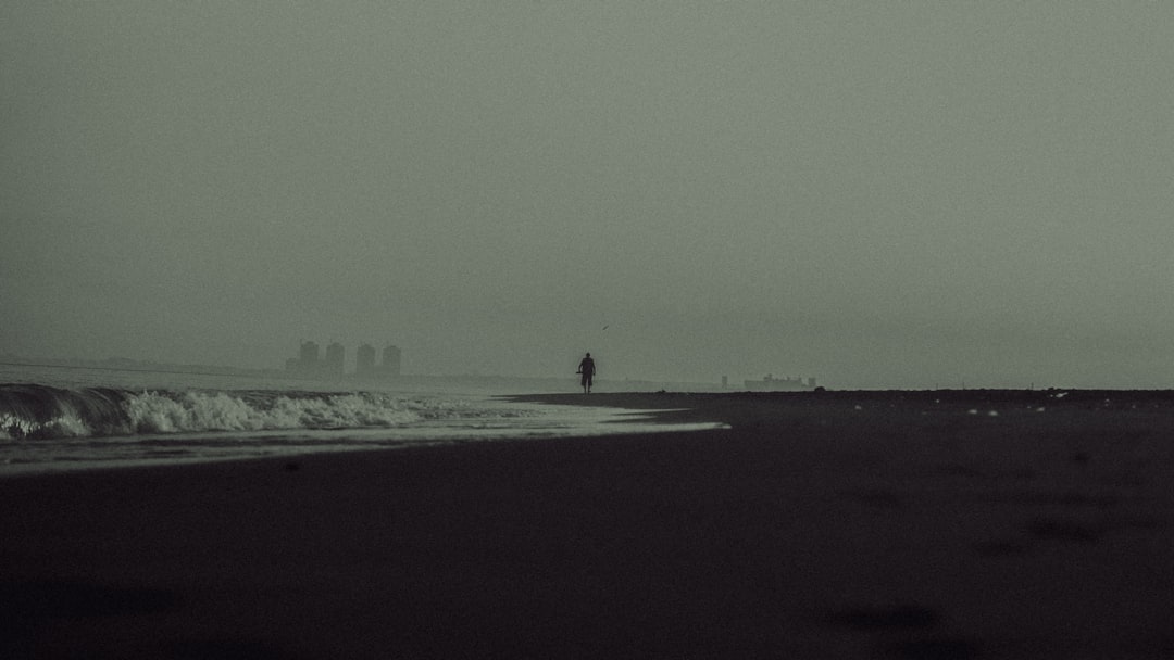 person walking on beach during daytime