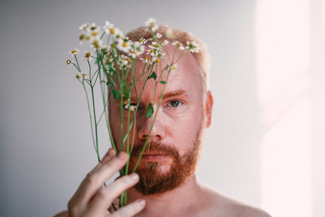 man holding white and green flower bouquet