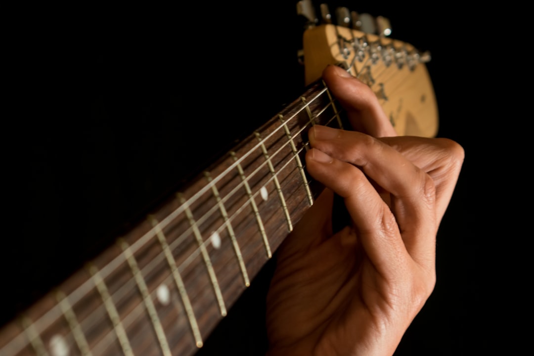 a person playing a guitar with their fingers